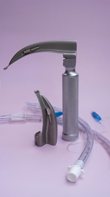 conjunto para laringoscopio de intubación y máscara para ventilador, un tubo endotraqueal sobre fondo rosa