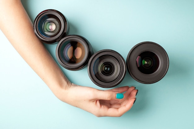 Conjunto de lentes fotográficas sobre un fondo de color, la selección y comparación de equipos fotográficos, las manos sostienen equipos fotográficos