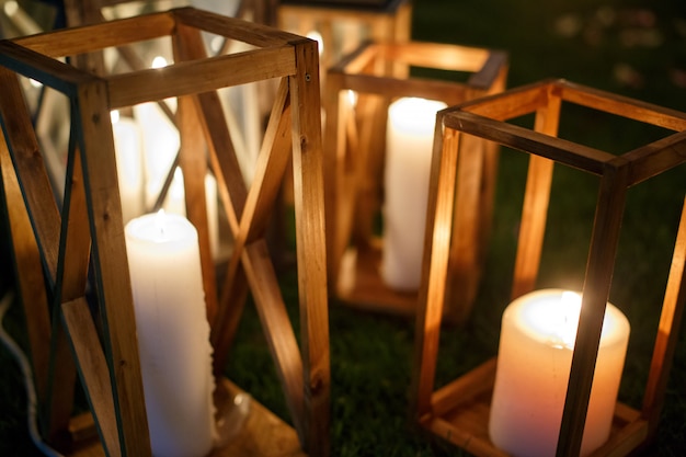 Conjunto de linternas de madera con fuego de cerca. luces de velas de madera