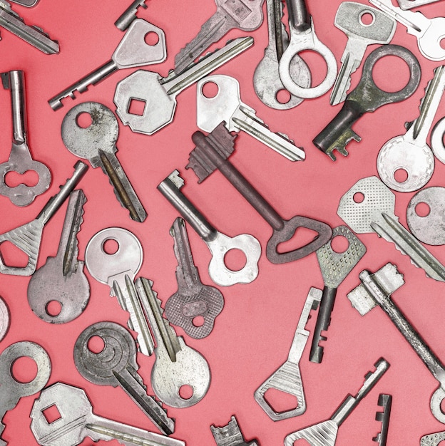 Conjunto de llaves sobre fondo rosa. Cerradura de puerta con llaves y cajas fuertes para seguridad de la propiedad y protección de la casa.