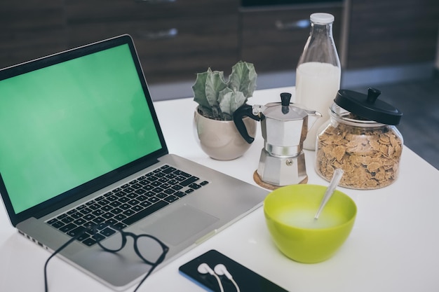 Foto conjunto de mesa para el desayuno cocina en el fondo comida natural y dispositivos de tecnología vista interior