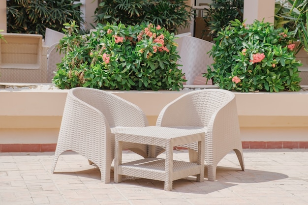 Conjunto de muebles de jardín de mimbre de plástico. Una mesa y dos sillones de plástico de mimbre.