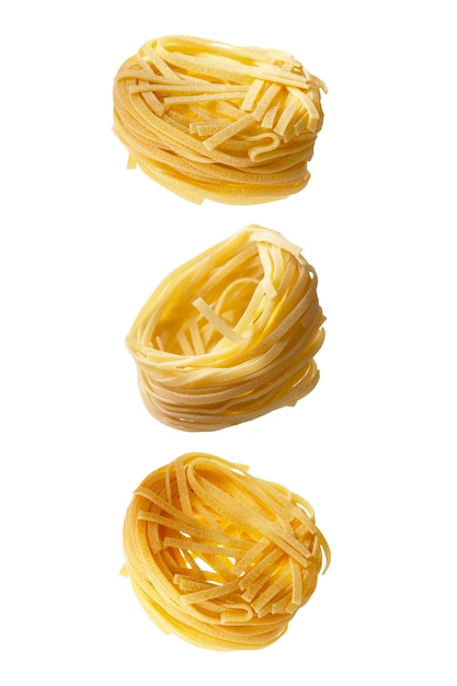 Conjunto de nido de pasta de fideos fettuccine sin cocer aislado sobre fondo blanco que levita la comida