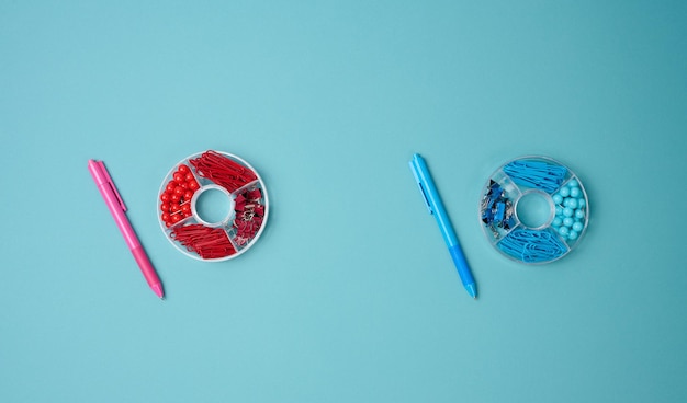 Conjunto de objetos de papelería, botones de clip de papel y clip sobre un fondo azul Vista desde arriba