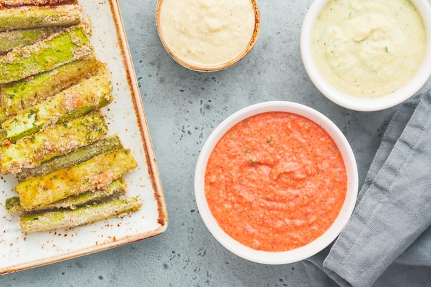 Conjunto de palitos de verduras de temporada horneados de calabacín y zanahorias con salsa y hummus Comida vegetariana saludable Vista plana superior