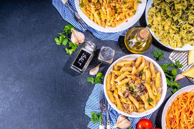 Conjunto de pasta con diferentes salsas sobre fondo de azulejos blancos Spaghetti farfalle penne fusilli pasta con mariscos espinacas carbonara salsa de tomate Cena italiana Concepto de comida mediterránea