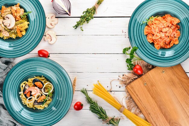 Un conjunto de pastas cocidas en platos Sobre un fondo de madera Cocina italiana Vista superior Espacio de copia