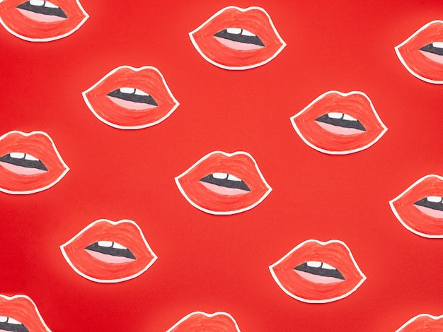 Conjunto de pegatinas en forma de labios sobre fondo rojo.
