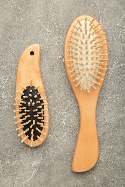 Foto conjunto de peine y cepillo para el pelo en pared gris. vista superior