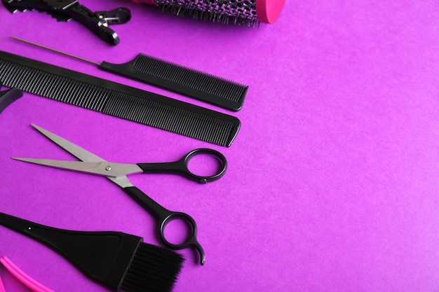 Conjunto de peluquería con varios accesorios sobre fondo violeta