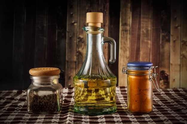 El conjunto de pimienta pimentón y aceite sobre un fondo de madera rústica