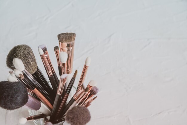 un conjunto de pinceles para aplicar cosméticos en un espacio de copia de fondo blanco. pinceles de maquillador para maquillaje