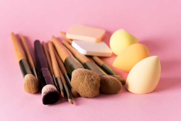 Conjunto de pinceles de maquillaje sobre fondo rosa Maquillaje Cosmético Belleza Blender Esponja de silicona arriba