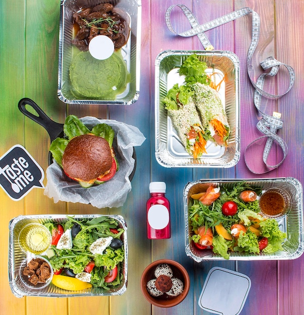 Un conjunto de platos dietéticos en recipientes sobre un fondo de madera coloreada Dieta para llevar y comida saludable