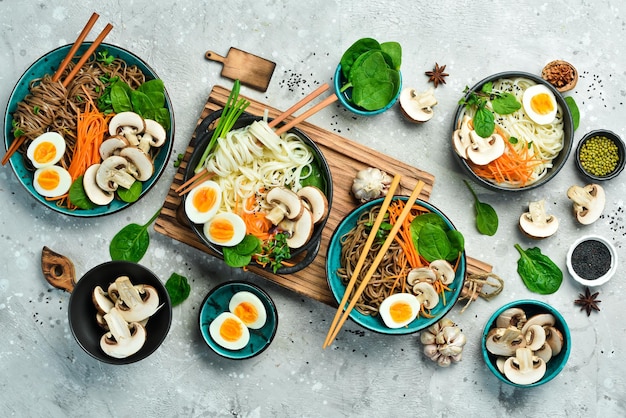 Conjunto de platos japoneses con fideos hongos huevo y microgreens Udon y fideos soba pancarta de comida vista superior