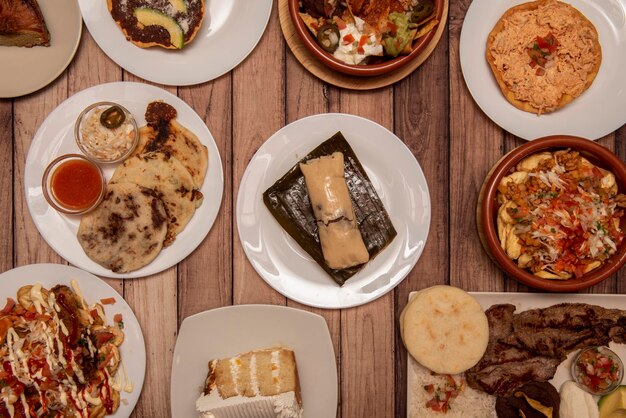 Foto conjunto de platos típicos de la cocina centroamericana con tamales catrachas quesillo de carne asada