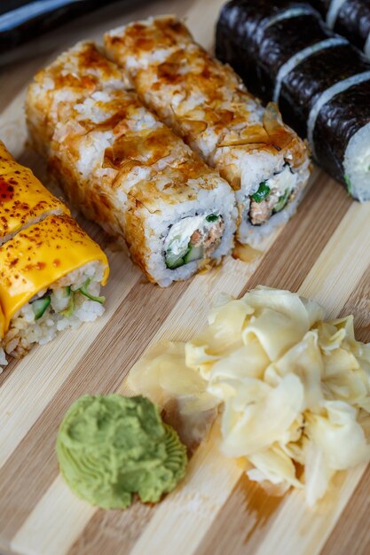 Conjunto de platos tradicionales japoneses. Rollos de sushi, nigiri, salmón crudo, arroz, queso crema, aguacate, jengibre en escabeche.