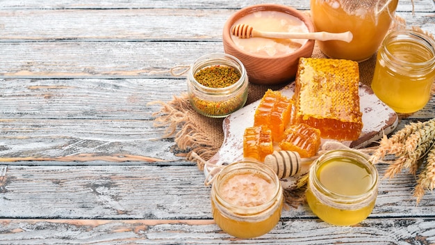 Conjunto de productos de abejas y miel sobre un fondo blanco de madera Espacio libre para texto Vista superior