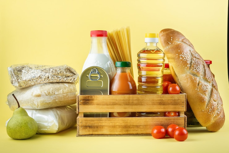 Foto un conjunto de productos de almacenamiento a largo plazo en una pared amarilla. donaciones de alimentos o concepto de entrega de alimentos.