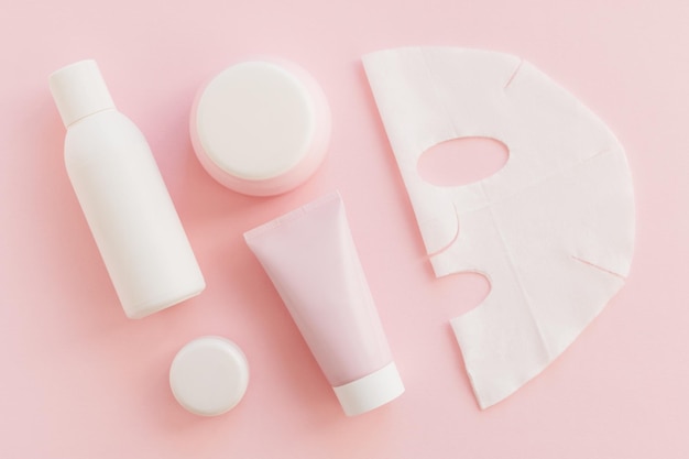 Conjunto de productos cosméticos para el cuidado facial en color blanco sobre fondo rosa Belleza Autocuidado