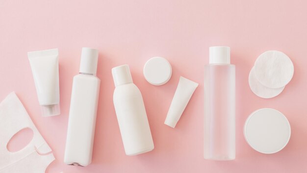 Conjunto de productos cosméticos para el cuidado facial en color blanco sobre fondo rosa Belleza Autocuidado