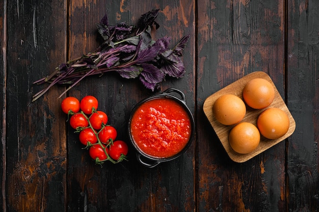 Conjunto de puré de tomate, sobre fondo de mesa de madera oscura antigua, vista superior plana, con espacio de copia para texto