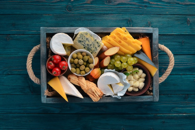 Un conjunto de queso en una caja de madera Parmesano Mamasam Mozzarella Brie Feta Vista superior Sobre un fondo de madera Espacio libre para su texto