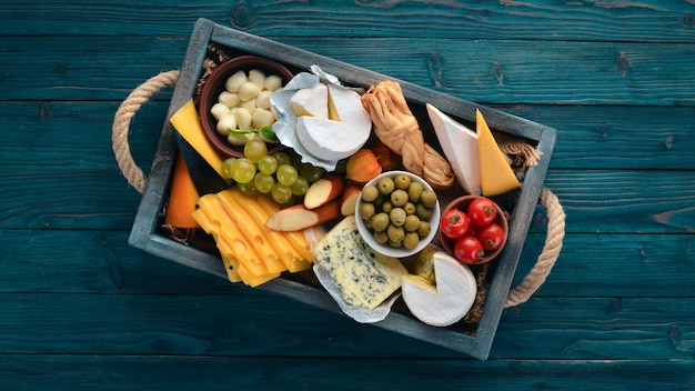 Un conjunto de queso en una caja de madera Parmesano Mamasam Mozzarella Brie Feta Vista superior Sobre un fondo de madera Espacio libre para su texto