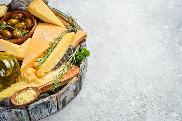 Conjunto de quesos duros en una cesta de madera Queso parmesano cortado en trozos Queso Vista superior Sobre un fondo de piedra gris