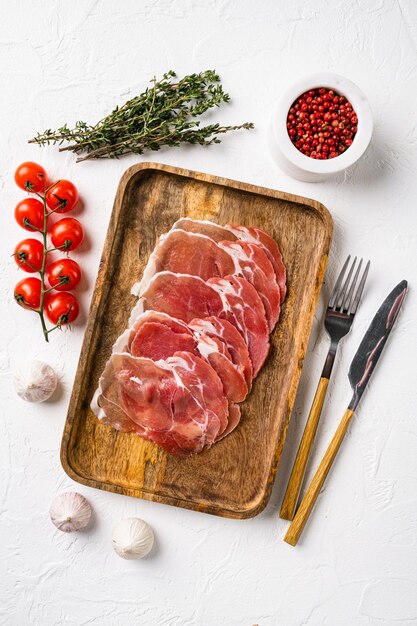 Conjunto de rebanadas de jamón sabroso, sobre fondo de mesa de piedra blanca, vista superior plana