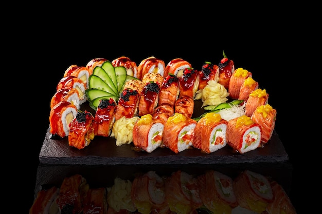 Conjunto de rollos nigiri sushi y gunkan maki con salmón sobre fondo negro