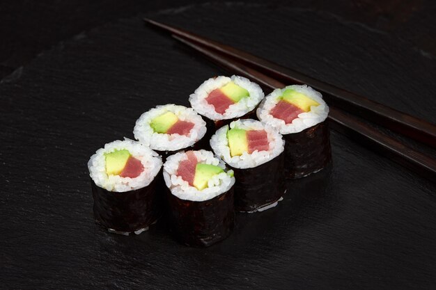 Conjunto de rollos de sushi de atún en fondo de escritorio negro