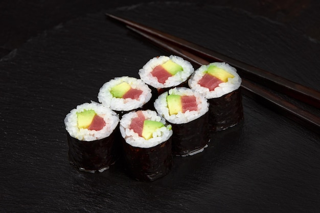 Conjunto de rollos de sushi de atún sobre fondo de escritorio negro