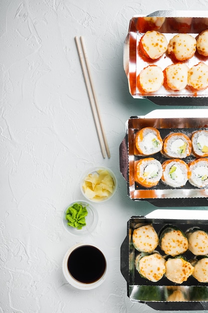 Conjunto de rollos de sushi en caja de comida de entrega, en piedra blanca