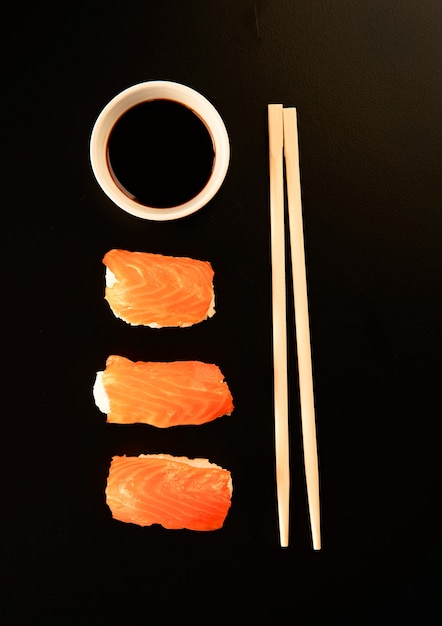 Conjunto de rollos de sushi y palillos, aislado en negro