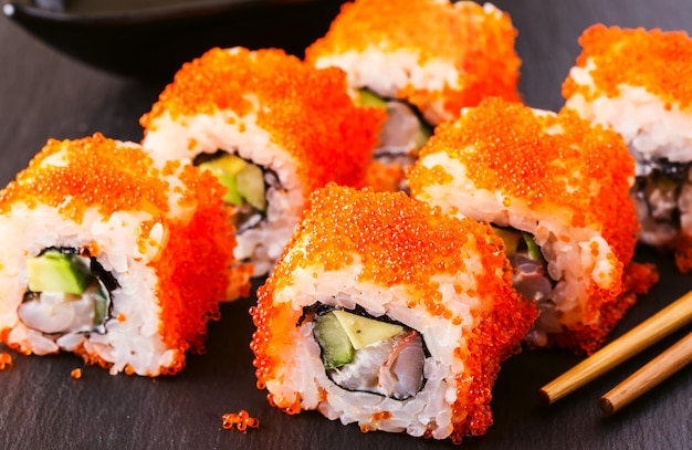 Conjunto de rollos de sushi en un plato con palillos