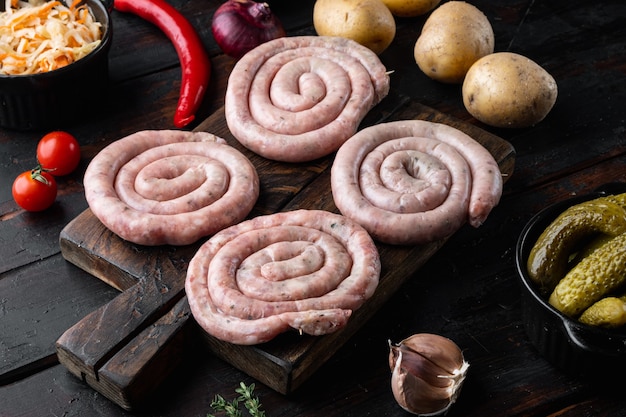 Conjunto de salchicha de carne cruda, sobre fondo de mesa de madera oscura antigua