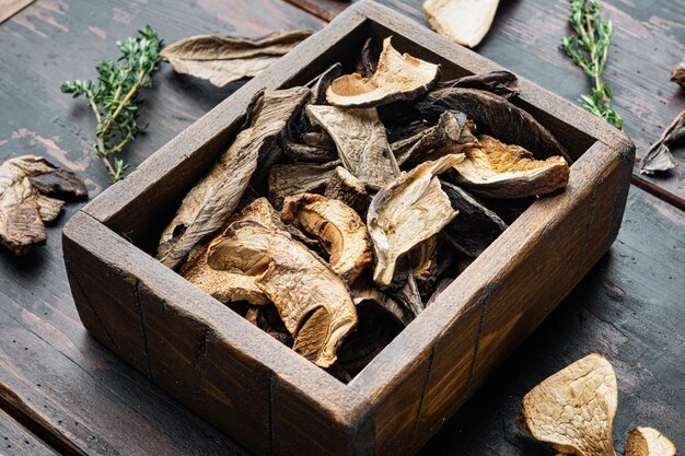 Conjunto de setas secas silvestres Boletus, sobre fondo de mesa de madera oscura antigua