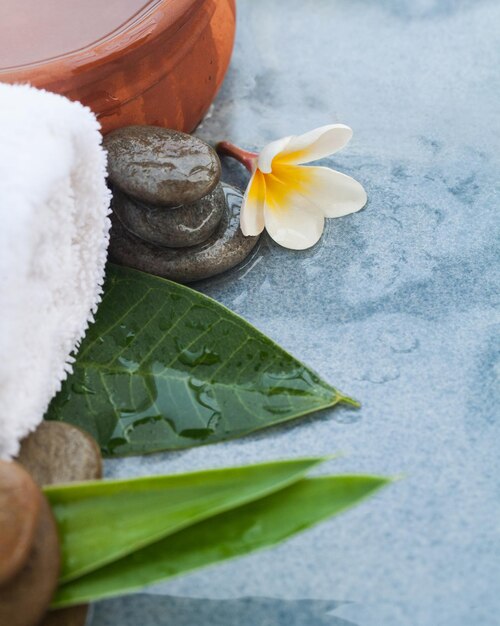 Conjunto de spa con flores y piedras para tratamiento de masaje en azul.