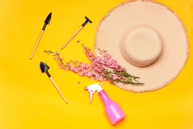 Foto conjunto de suministros de jardinería con flores sobre fondo de color