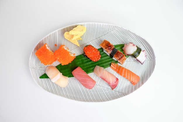 Conjunto de sushi japonés nigiri de comida tradicional en plato blanco