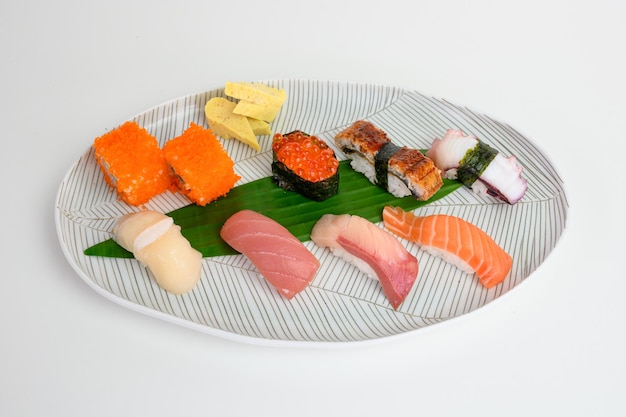 Conjunto de sushi japonés nigiri de comida tradicional en plato blanco