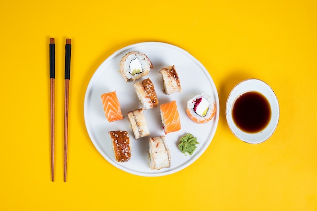 Un conjunto de sushi roll diferente tipo en un espacio amarillo. Vista superior. Comida tradicional asiática