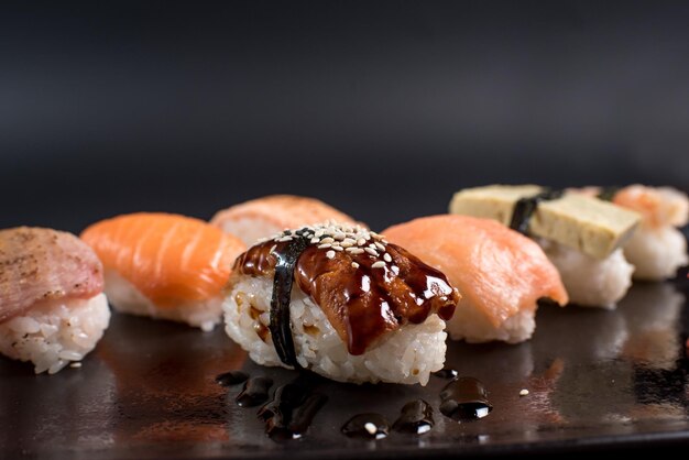 Conjunto de sushi sashimi sobre fondo negro