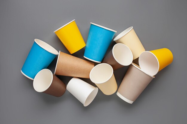 Conjunto de tazas de papel de colores para café sobre un fondo gris Vista superior Concepto de cero residuos