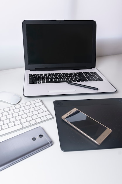 Foto conjunto de tecnología computadora portátil blanca, tableta gráfica, teléfono inteligente, mouse y teclado