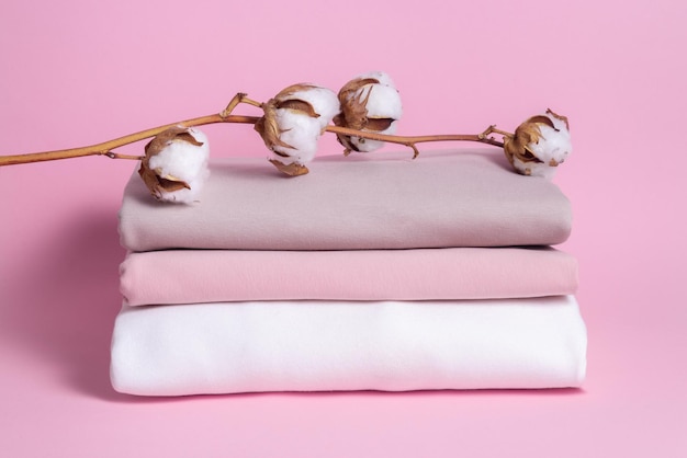 Conjunto de tela de algodón con rama de flor de algodón sobre fondo de madera
