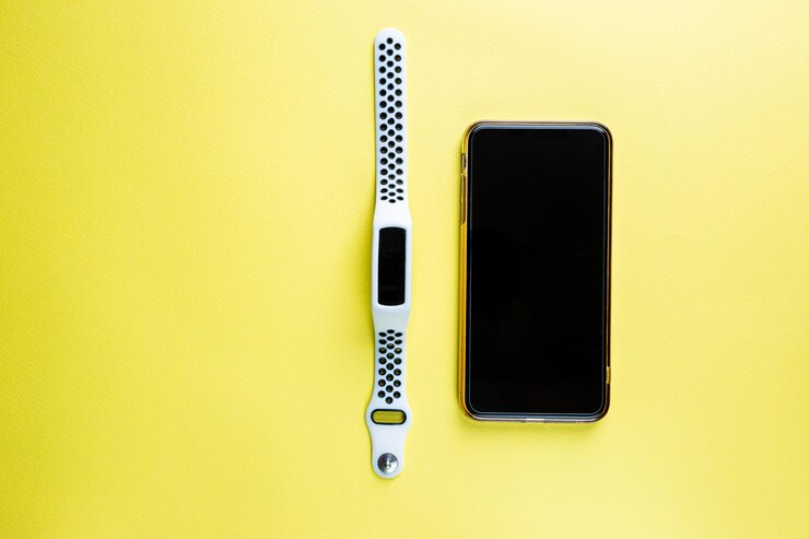 Foto conjunto de teléfono inteligente móvil y reloj inteligente en la vista superior de fondo de color amarillo