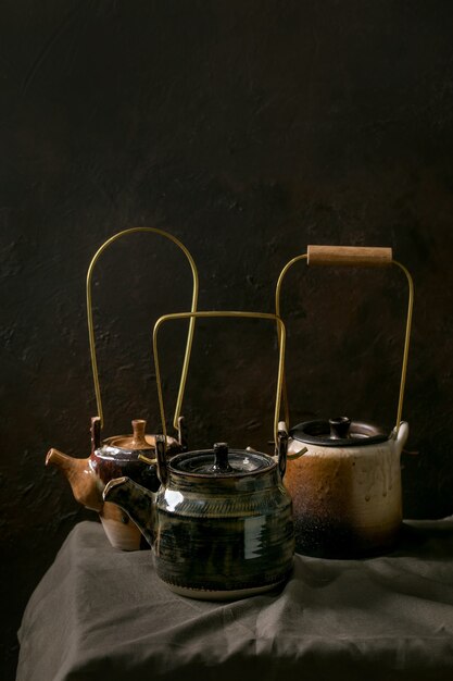 Foto conjunto de teteras de cerámica artesanales artesanales con fondo oscuro