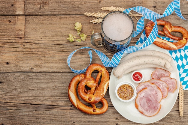 Conjunto tradicional da Oktoberfest Pretzels cerveja weisswurst e eisbein com mostarda festival alemão conceito de comida na moda fundo de madeira vista superior